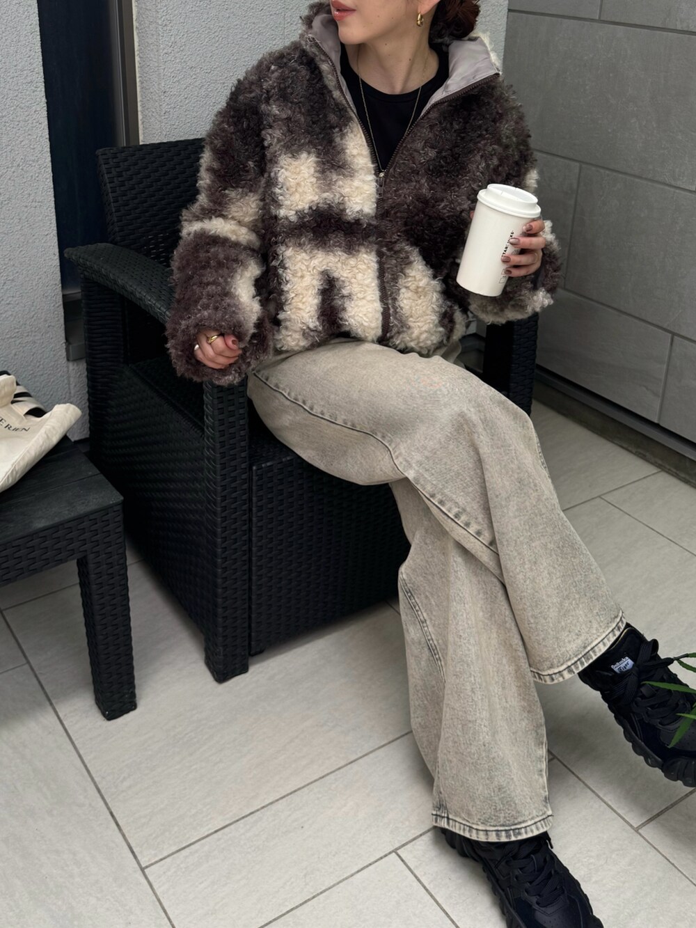 ベージュ系のデニムパンツ、ブラック系のスニーカーを着用したレディースの秋コーディネートの2枚目の写真