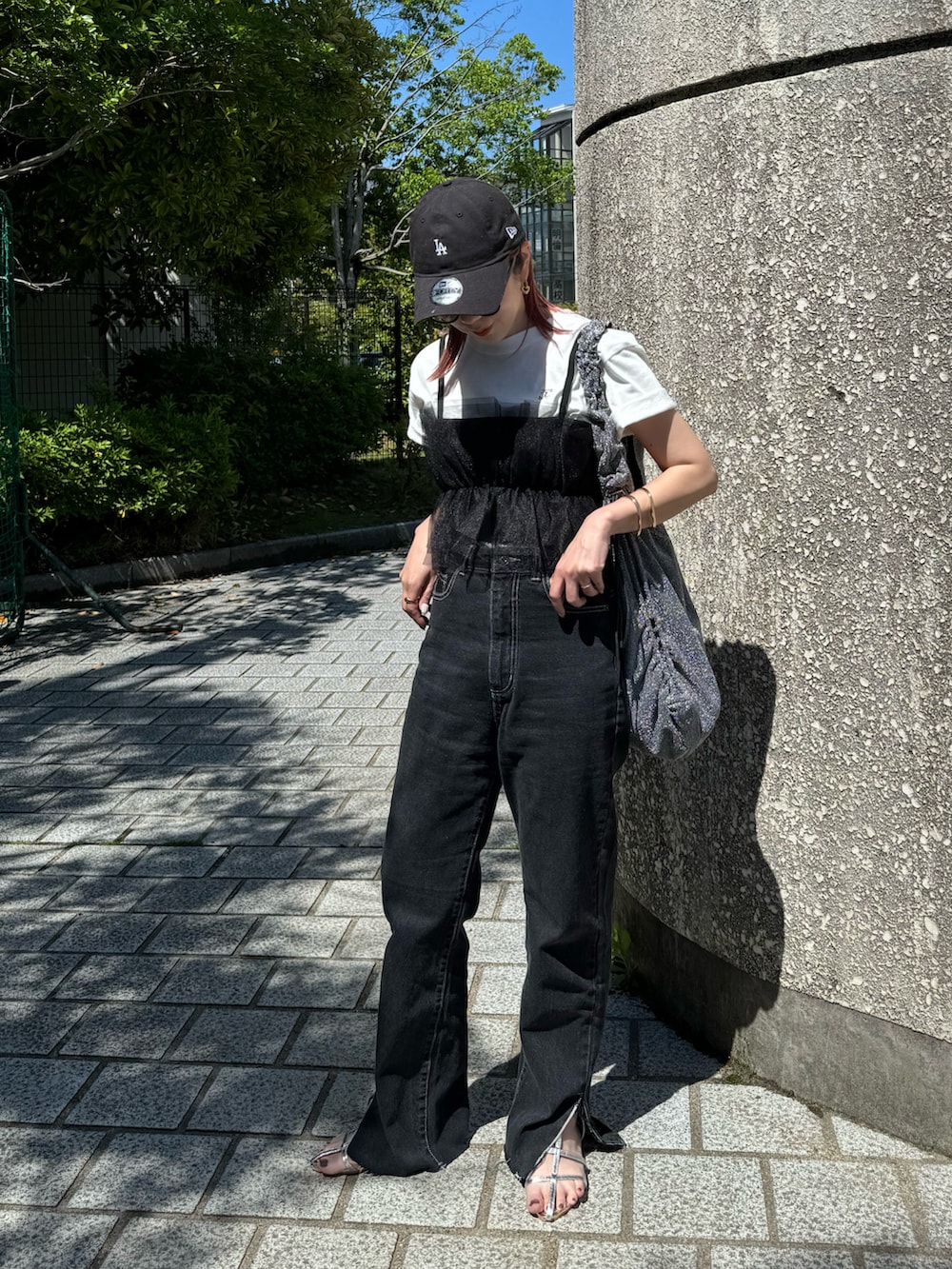 ホワイト系のTシャツ/カットソー、ブラック系のデニムパンツ、シルバー系のトートバッグを着用したレディースの春コーディネートの2枚目の写真