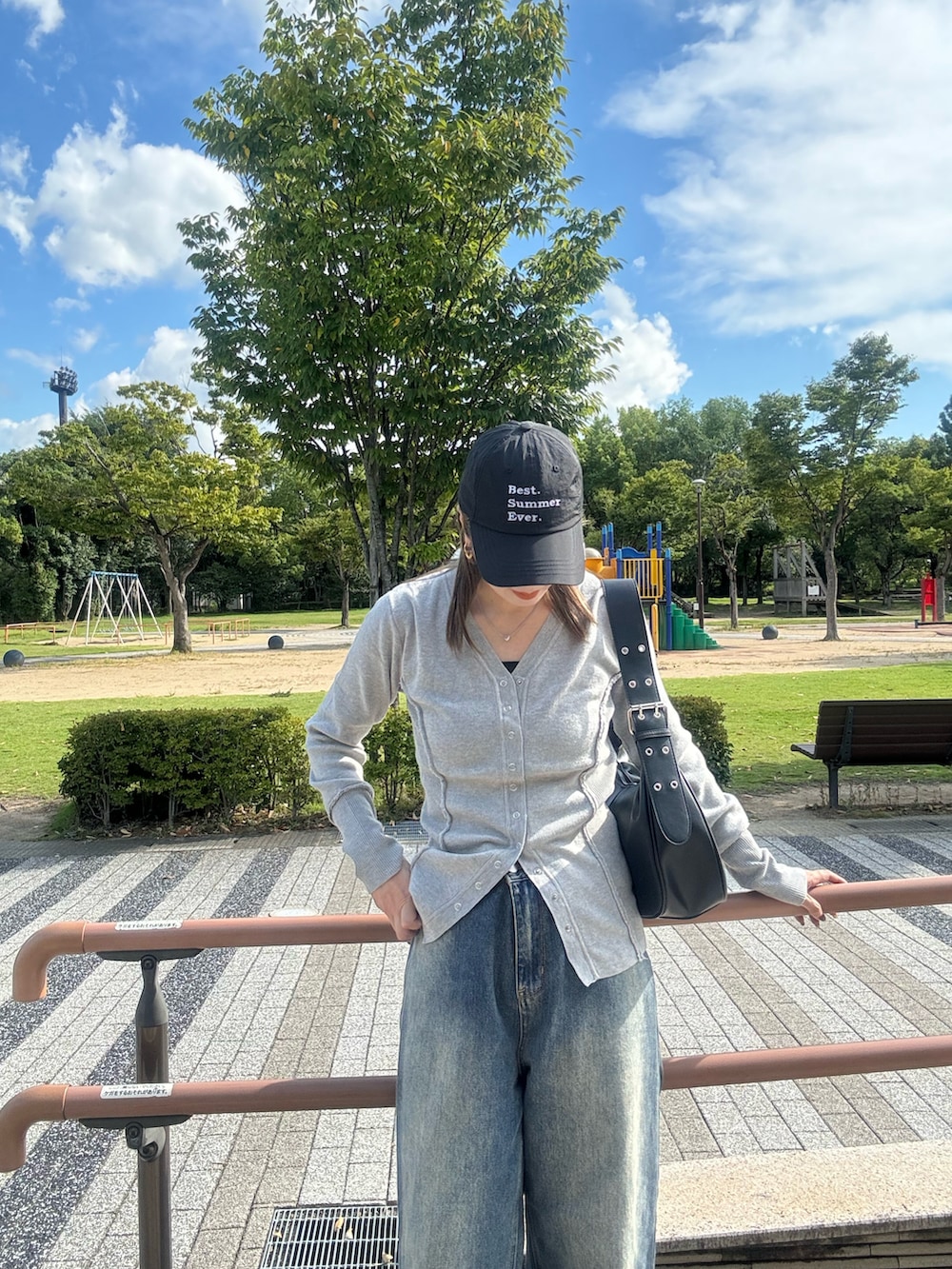 グレー系のカーディガン/ボレロ、ブルー系のデニムパンツ、ブラック系のハンドバッグを着用したレディースの夏コーディネートの2枚目の写真