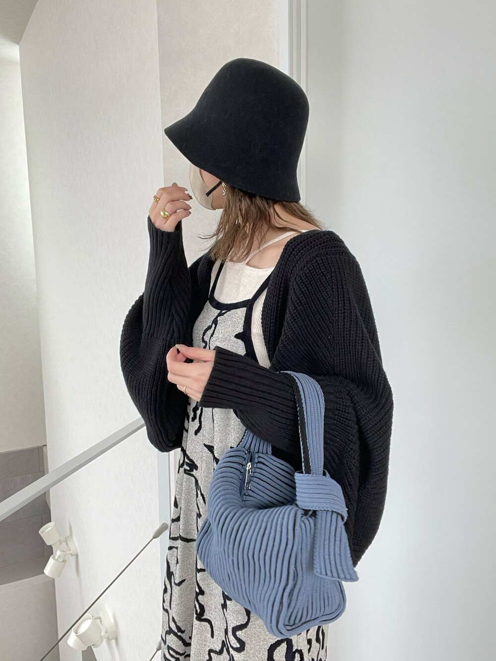 ホワイト系のワンピース、ホワイト系のニット/セーター、ブルー系のハンドバッグを着用したレディースの冬コーディネートの4枚目の写真