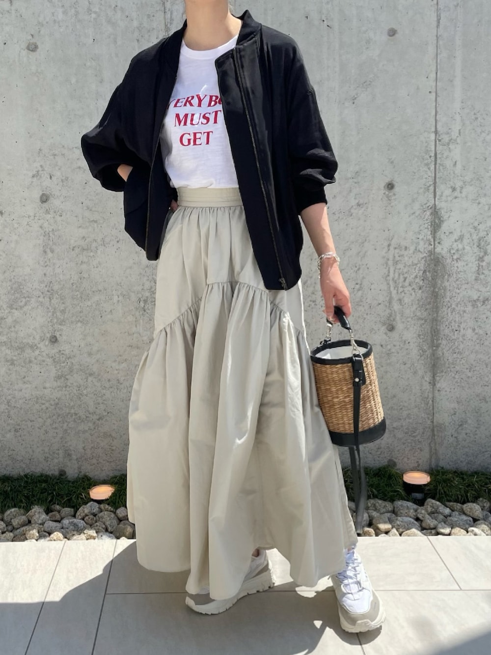 ブラック系のブルゾン、ホワイト系のTシャツ/カットソー、ホワイト系のスカートを着用したレディースの夏コーディネートの2枚目の写真