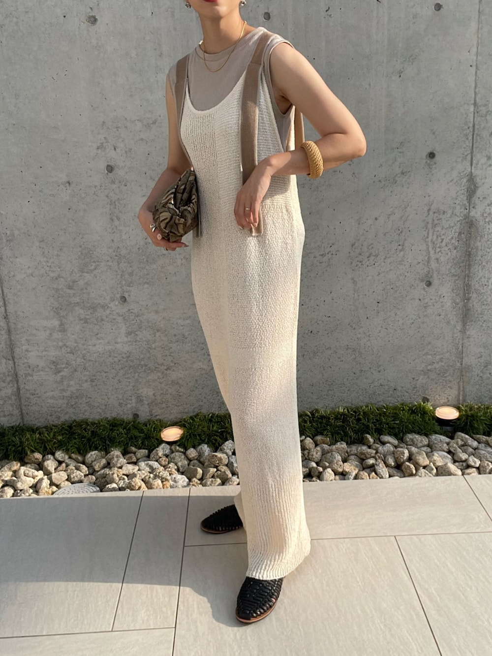 ホワイト系のワンピース、グリーン系のクラッチバッグ、ブラック系のサンダルを着用したレディースの夏コーディネートの3枚目の写真