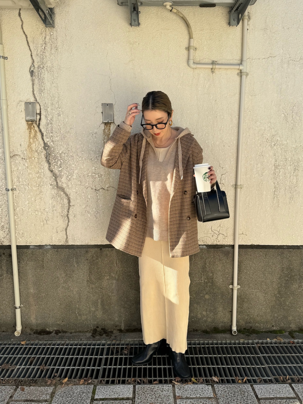 ホワイト系のワンピース、ブラック系のボストンバッグ、ベージュ系のニット/セーターを着用したレディースの秋コーディネートの2枚目の写真