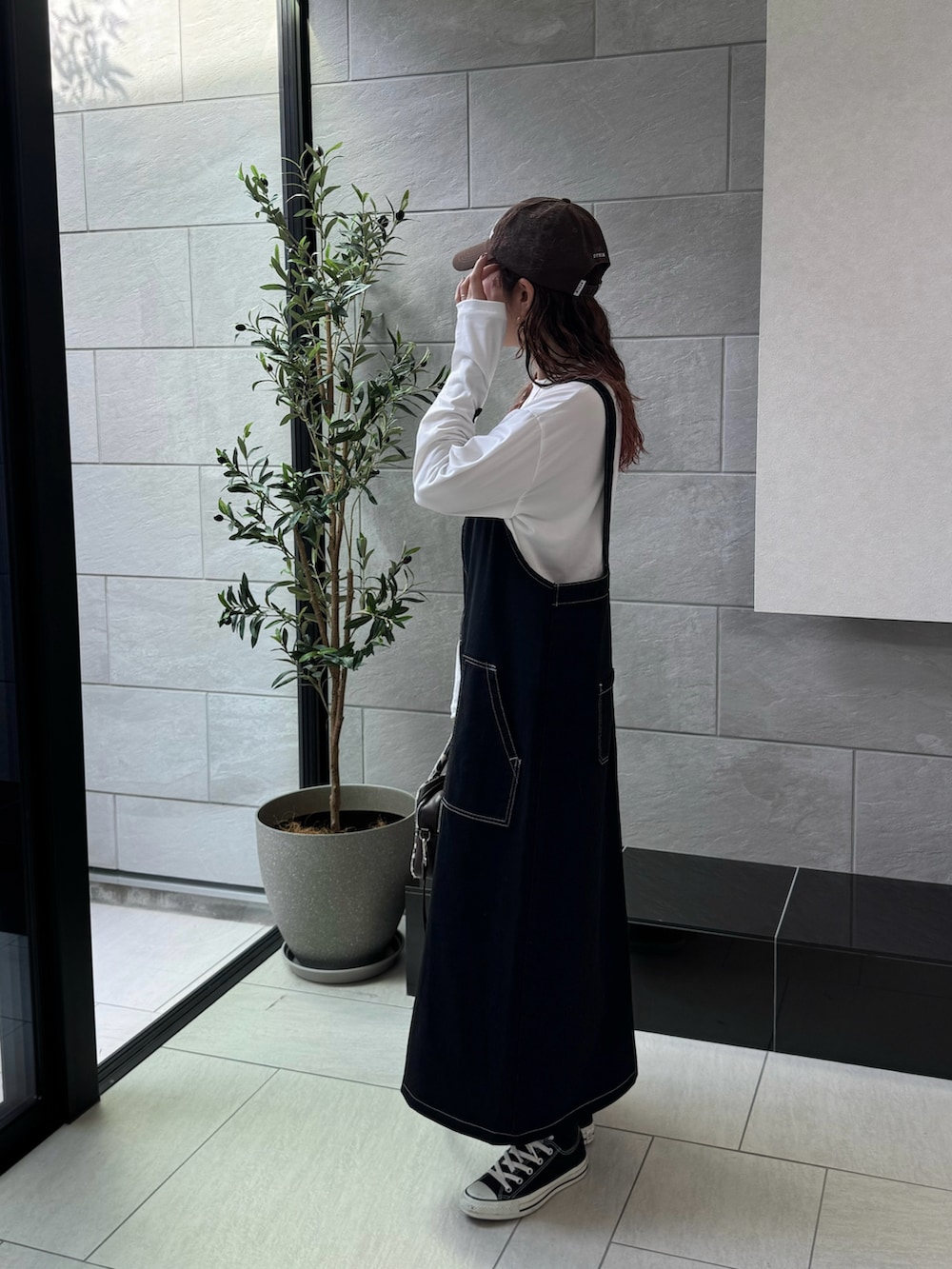 ホワイト系のTシャツ/カットソー、ブラウン系のキャップを着用したレディースの秋コーディネートの5枚目の写真