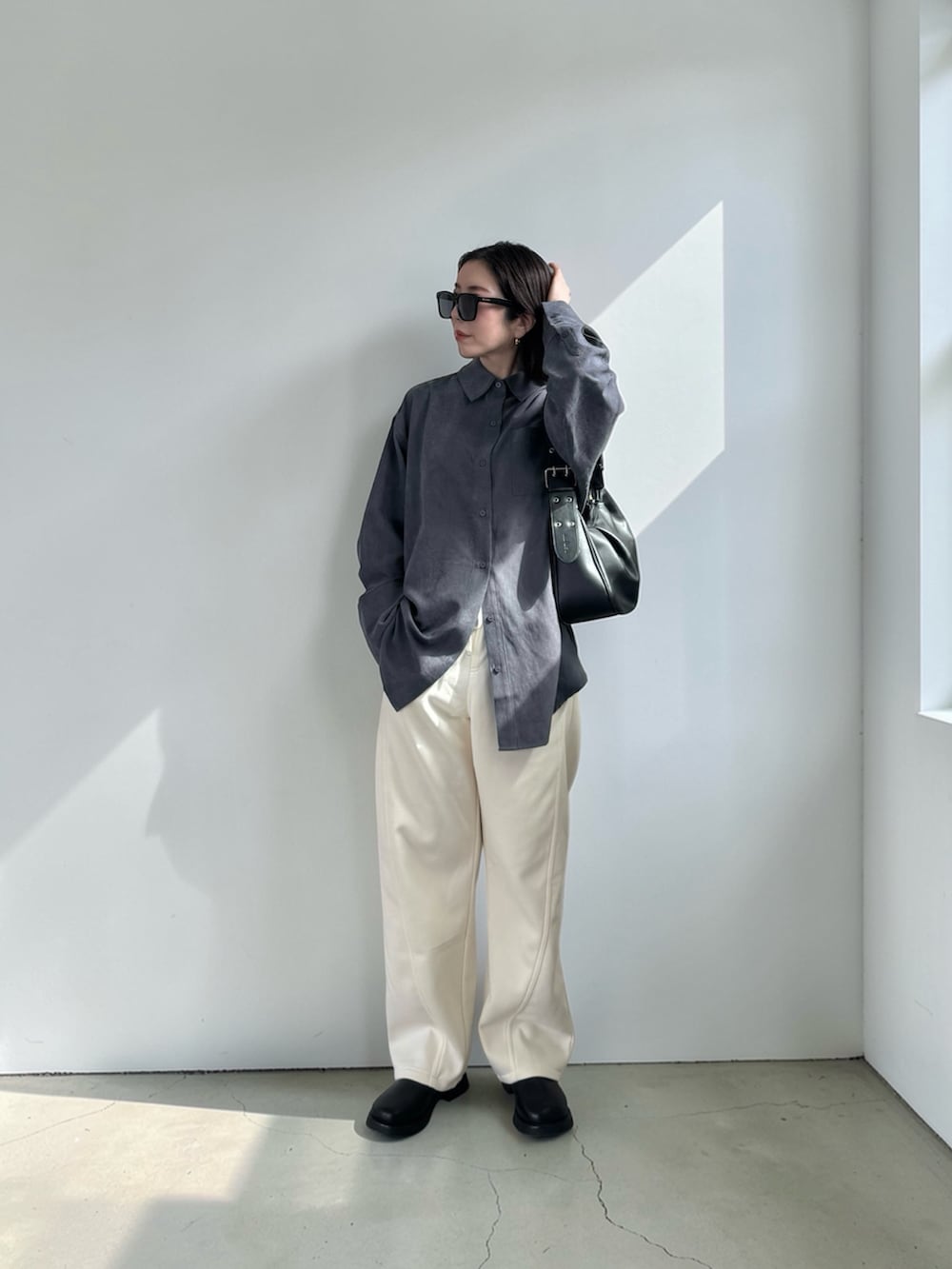 ホワイト系のスウェットパンツ、グレー系のシャツ/ブラウス、ブラック系のハンドバッグを着用したレディースの春コーディネートの2枚目の写真