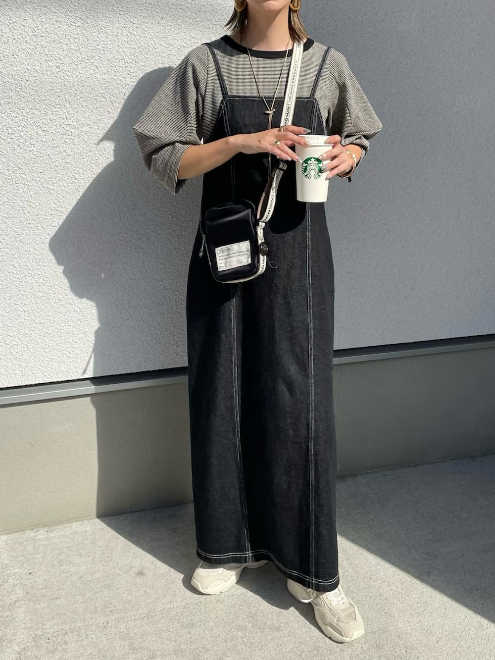 ブラック系のショルダーバッグ、ブラック系のTシャツ/カットソー、ブラック系のワンピースを着用したレディースの秋コーディネートの2枚目の写真