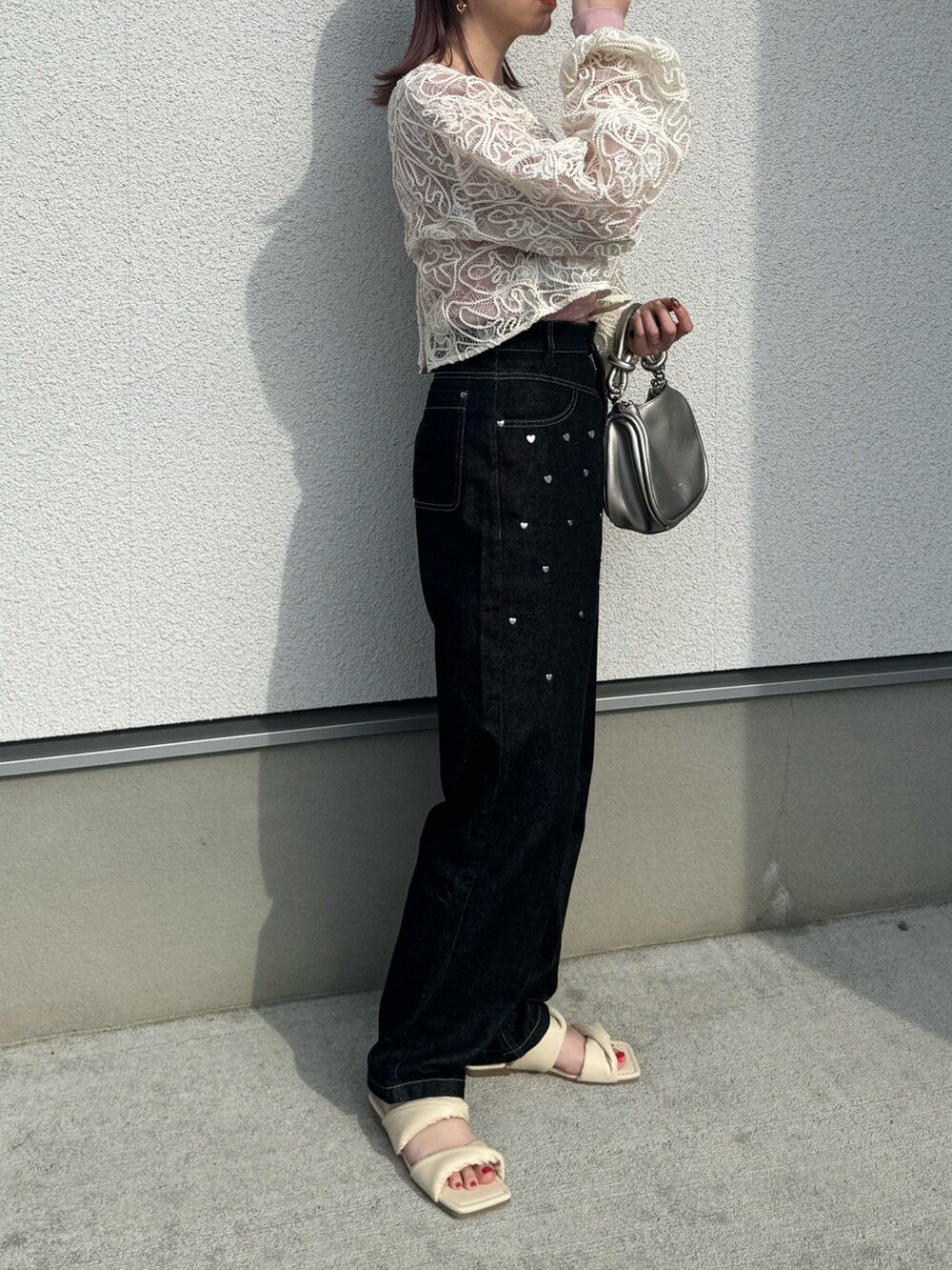ホワイト系のカーディガン/ボレロ、ブラック系のデニムパンツ、シルバー系のショルダーバッグを着用したレディースの春コーディネートの3枚目の写真