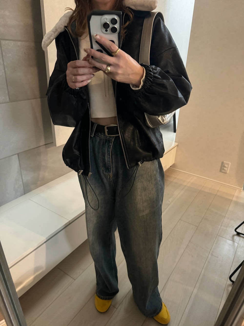 ブラック系のブルゾン、ホワイト系のTシャツ/カットソー、イエロー系のスニーカーを着用したレディースの秋コーディネートの5枚目の写真