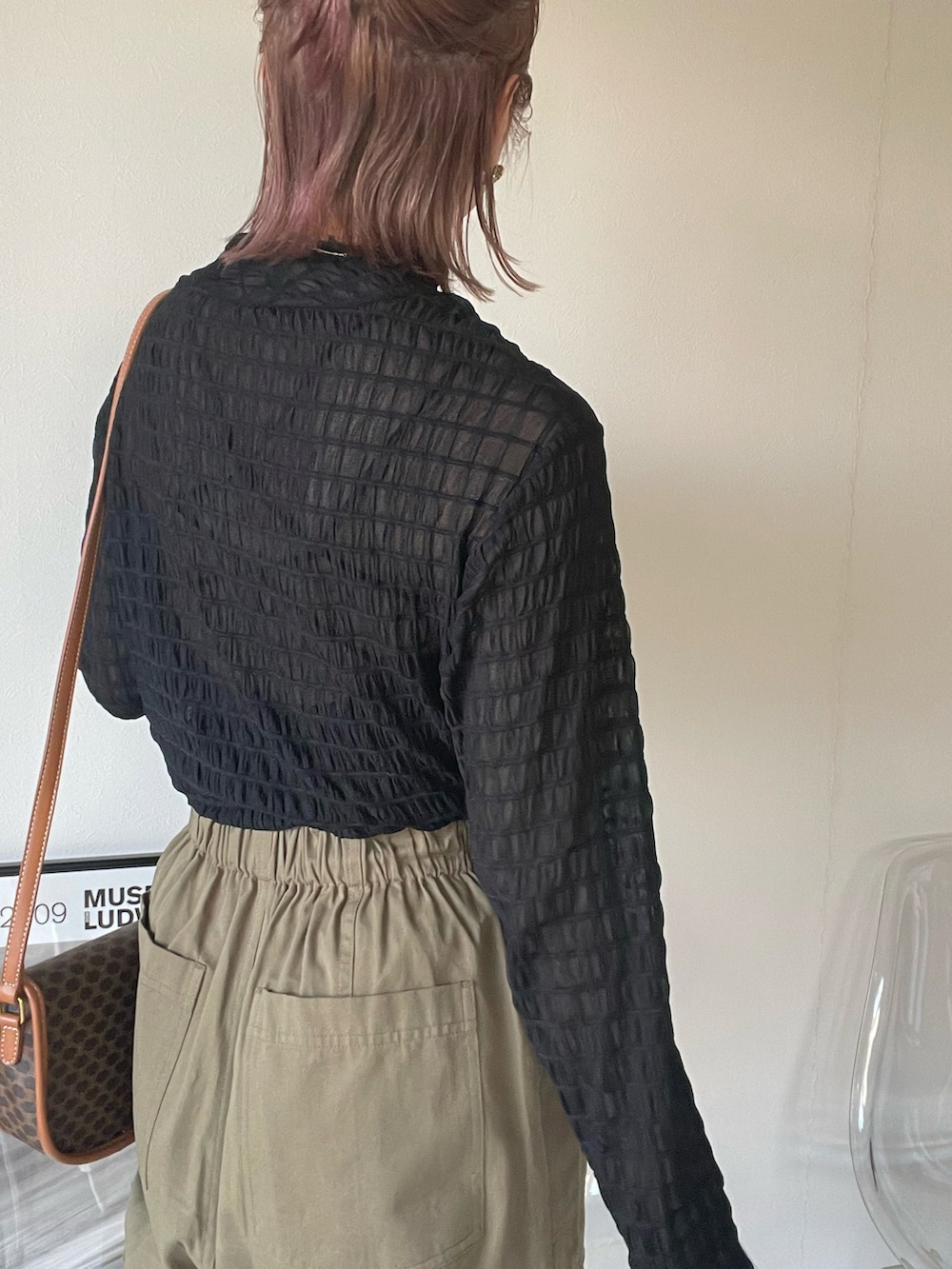ブラック系のTシャツ/カットソー、ブラウン系のベスト、ブラック系のブーツを着用したレディースの春コーディネートの3枚目の写真