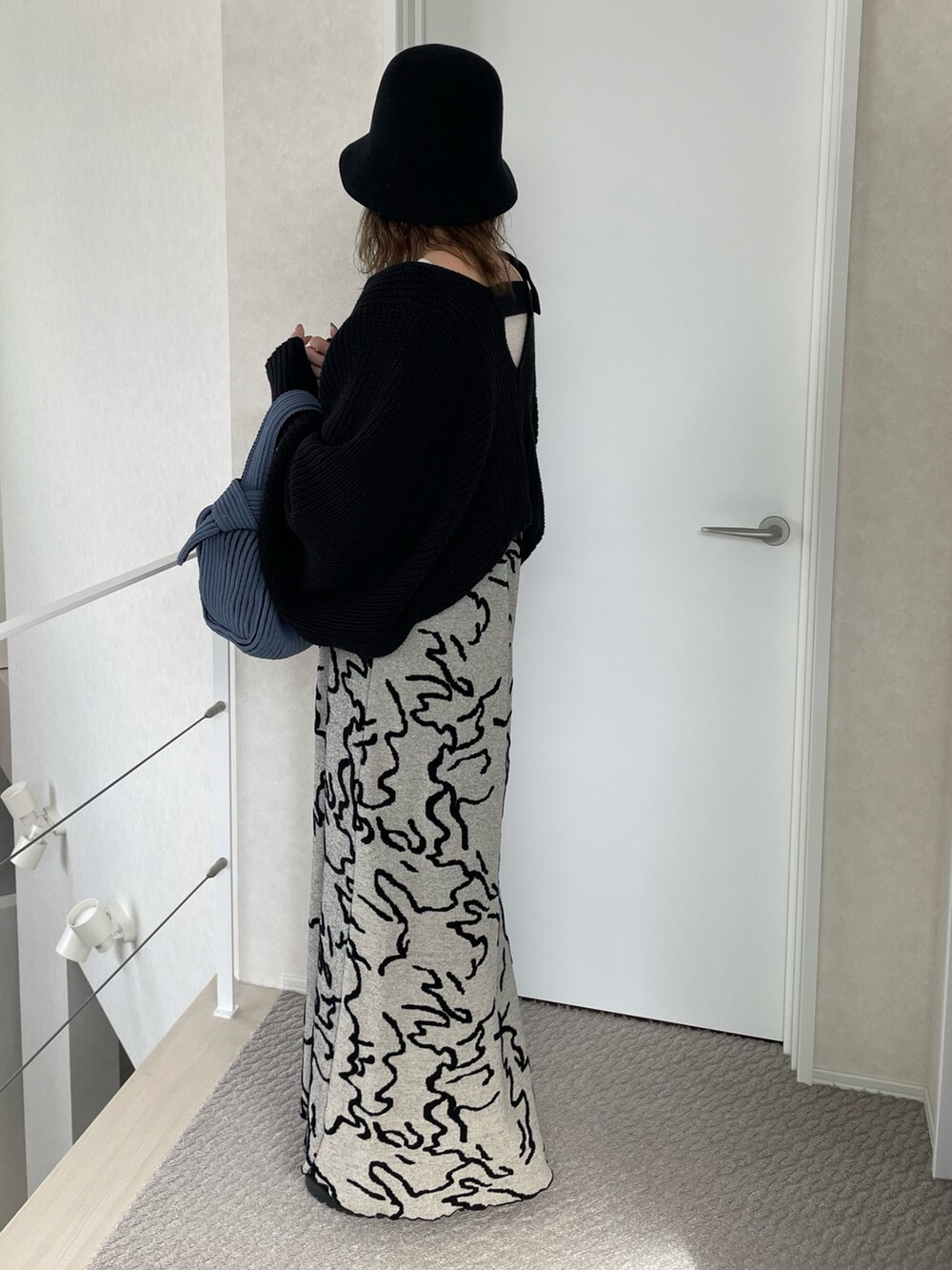 ホワイト系のワンピース、ホワイト系のニット/セーター、ブルー系のハンドバッグを着用したレディースの冬コーディネートの3枚目の写真