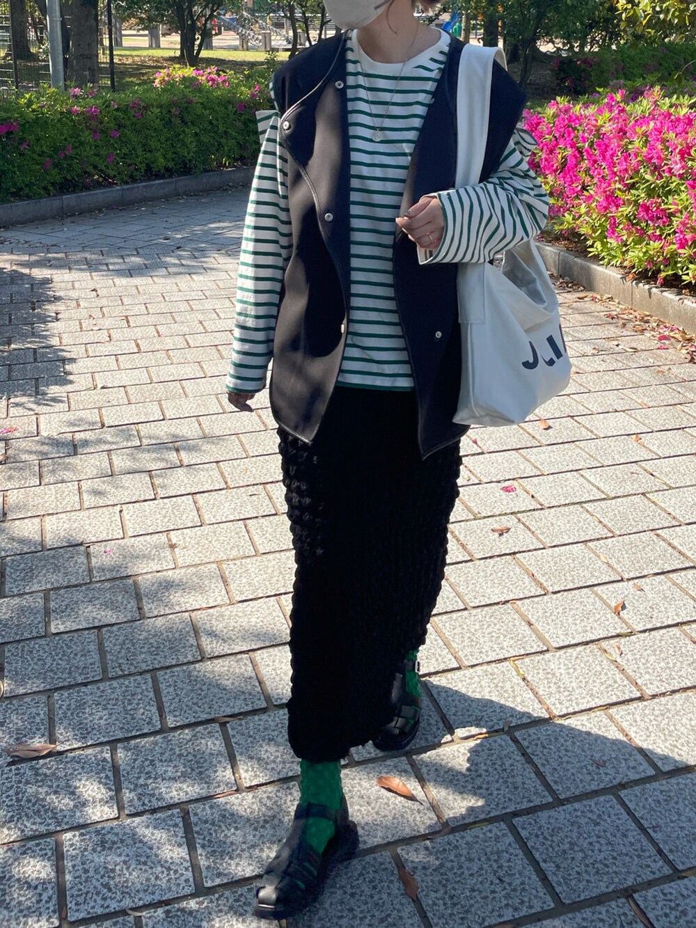 ブラック系のその他シューズ、ブラック系のスカート、ブラック系のベストを着用したレディースの春コーディネートの3枚目の写真