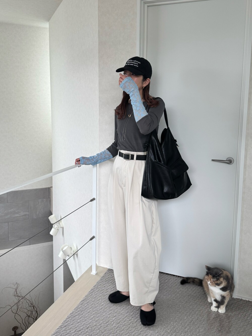 グレー系のTシャツ/カットソー、ホワイト系のチノパンツ、ブラック系のサンダルを着用したレディースの夏コーディネートの3枚目の写真