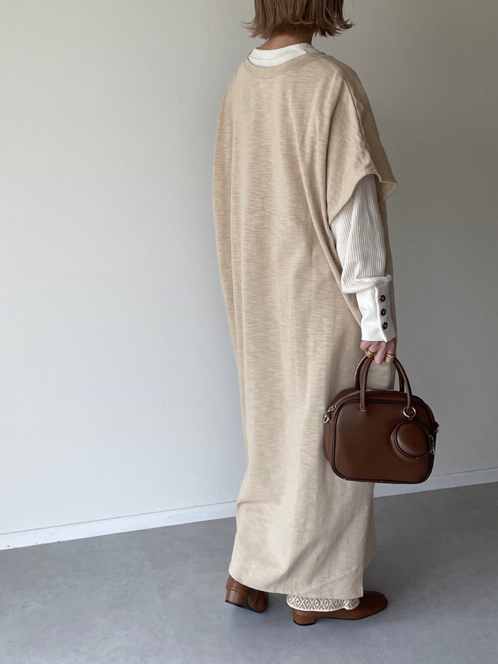 ベージュ系のワンピース、ホワイト系のTシャツ/カットソー、ベージュ系のその他パンツを着用したレディースの秋コーディネートの3枚目の写真