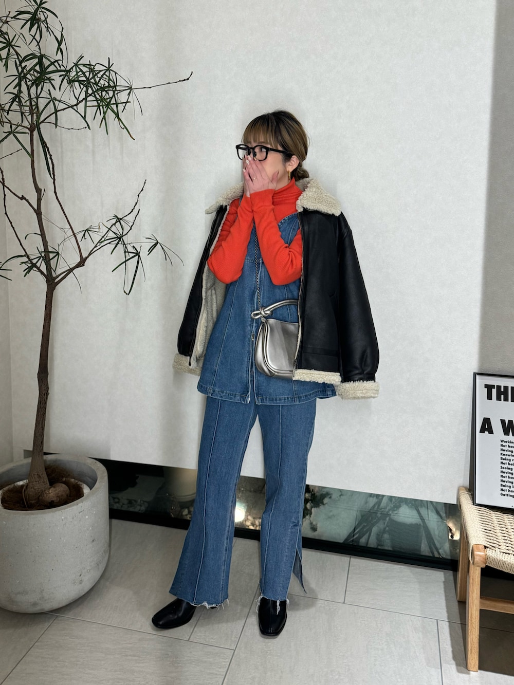 ブルー系のベスト、ブルー系のデニムパンツ、シルバー系のショルダーバッグを着用したレディースの冬コーディネートの2枚目の写真