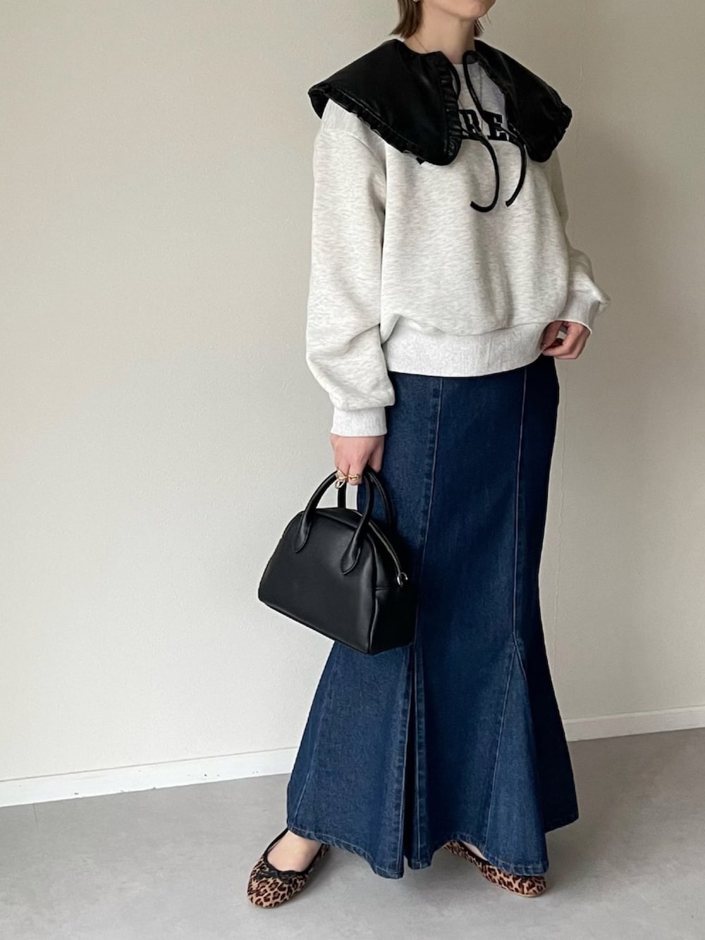 ブラック系のボストンバッグ、その他のバレエシューズ、ブルー系のスカートを着用したレディースの春コーディネートの3枚目の写真