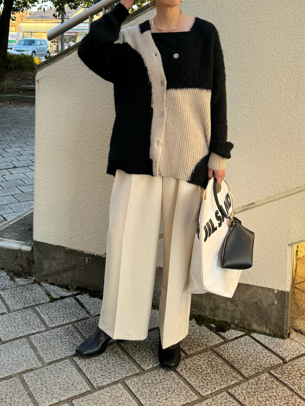 ブラック系のカーディガン/ボレロ、ホワイト系のその他パンツ、ブラック系のハンドバッグを着用したレディースの秋コーディネートの4枚目の写真