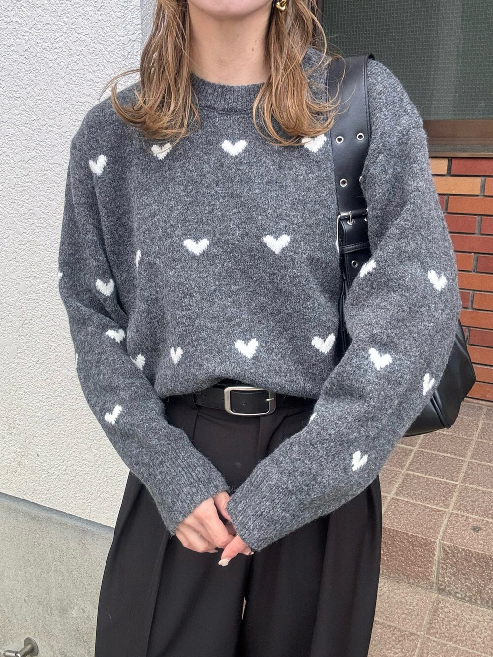 グレー系のニット/セーター、ブラック系のハンドバッグ、ブラック系のその他パンツを着用したレディースの秋コーディネートの4枚目の写真