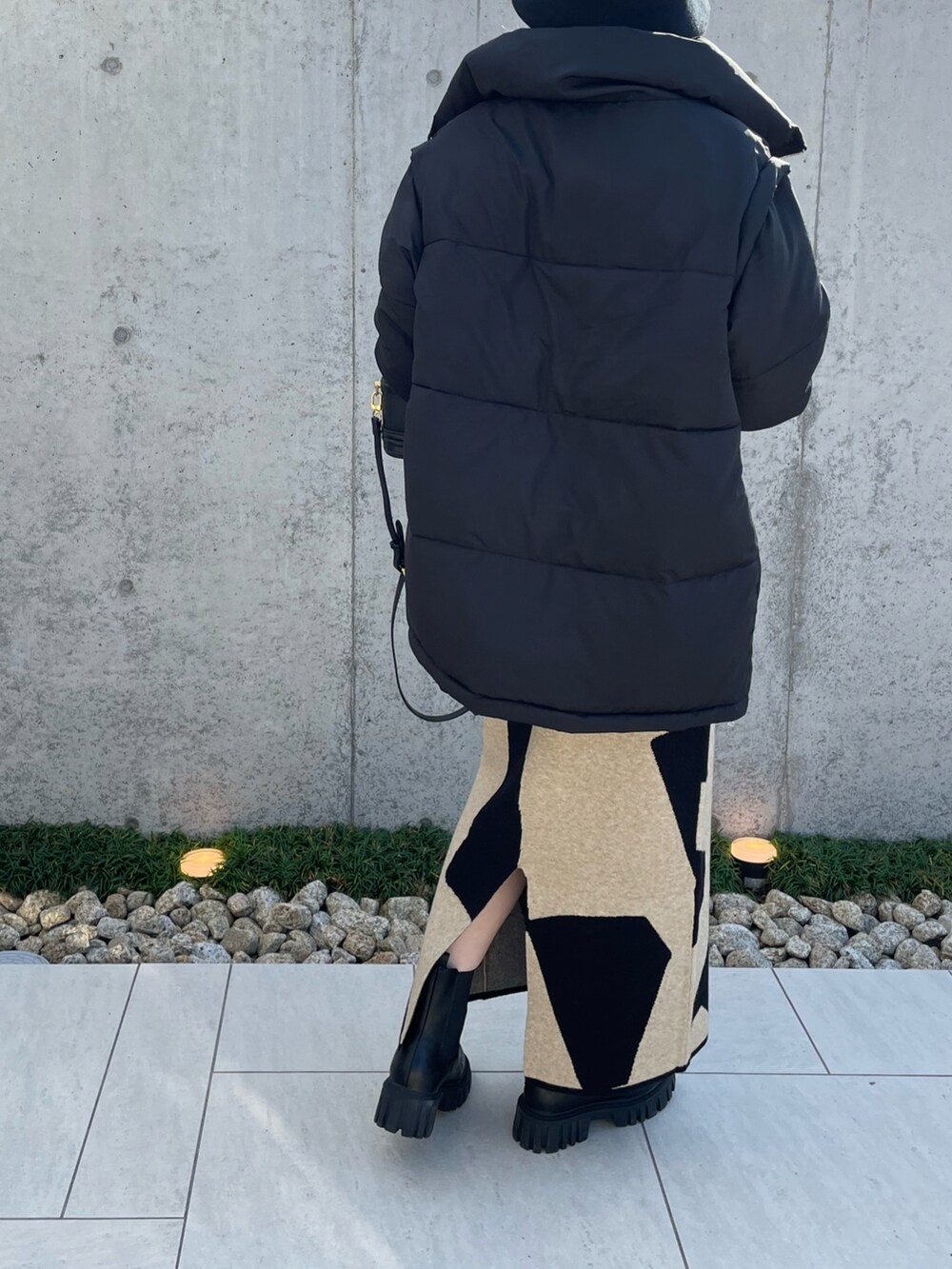 ブラック系のダウンジャケット/コート、ブラック系のブーツ、ブラック系のニット/セーターを着用したレディースの秋コーディネートの4枚目の写真