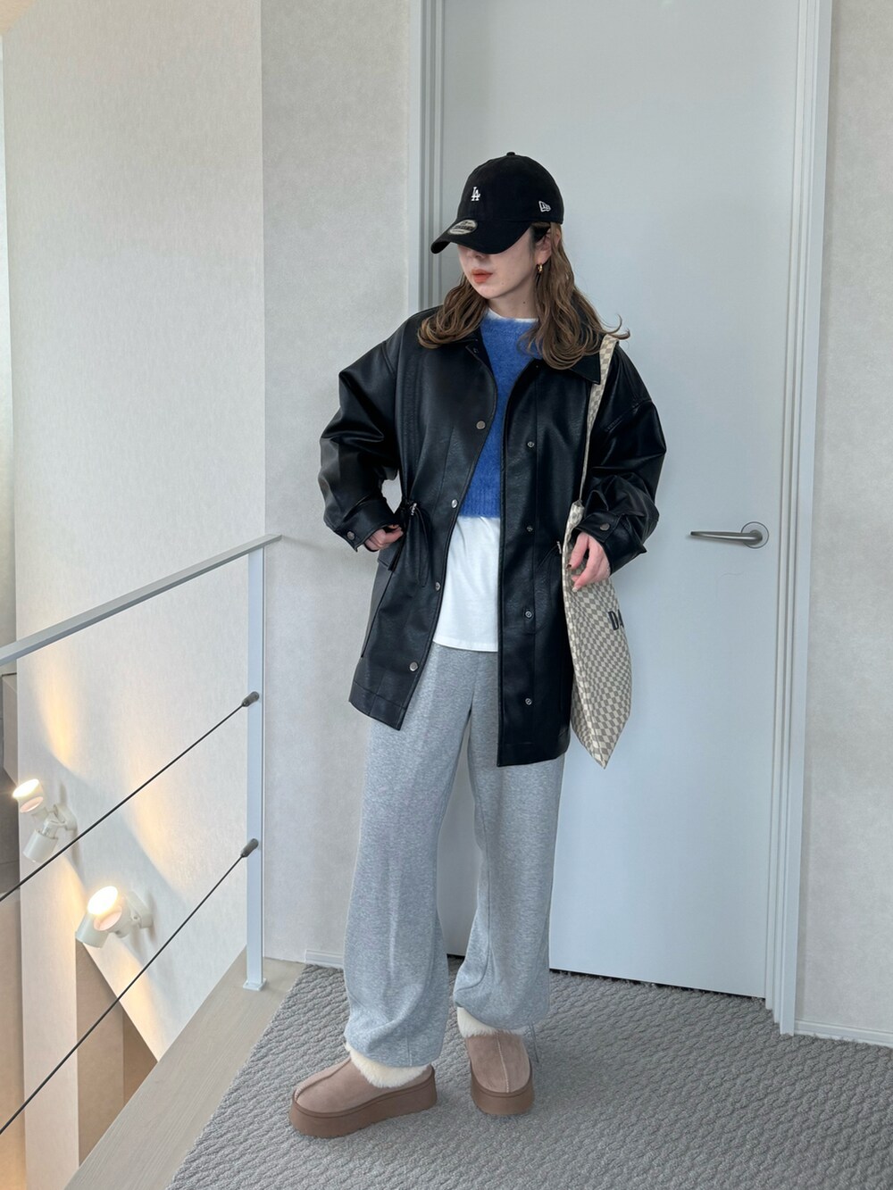 ブラック系のその他アウター、グレー系のスウェットパンツ、ベージュ系のトートバッグを着用したレディースの冬コーディネートの2枚目の写真