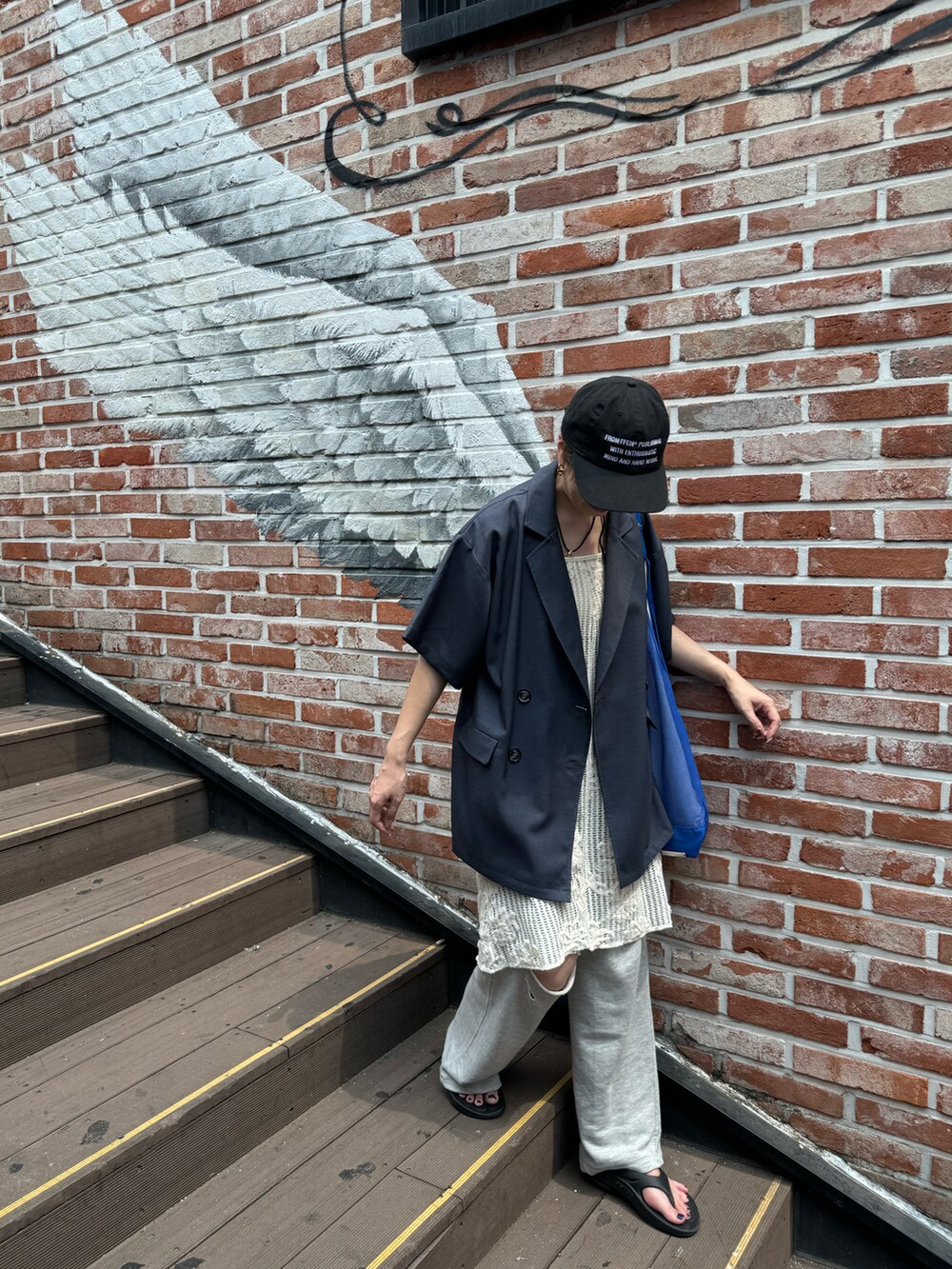 ホワイト系のワンピース、グレー系のスウェットパンツ、ブラック系のサンダルを着用したレディースの夏コーディネートの3枚目の写真