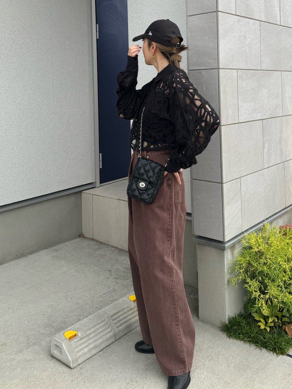 ブラウン系のデニムパンツ、ブラック系のショルダーバッグ、ブラック系のシャツ/ブラウスを着用したレディースの秋コーディネートの3枚目の写真