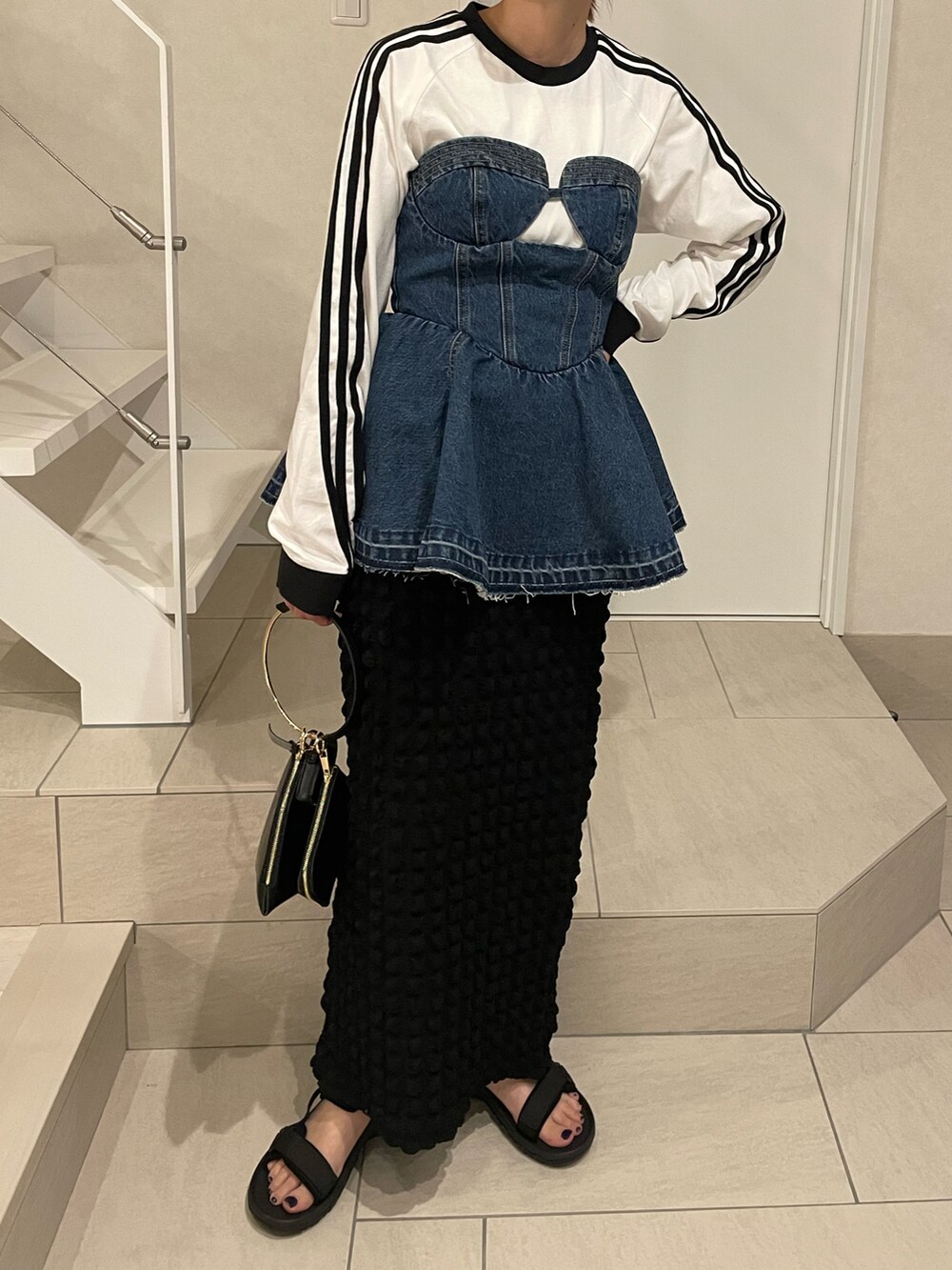 ブラック系のサンダル、ブルー系のTシャツ/カットソー、ブラック系のスカートを着用したレディースの春コーディネートの4枚目の写真