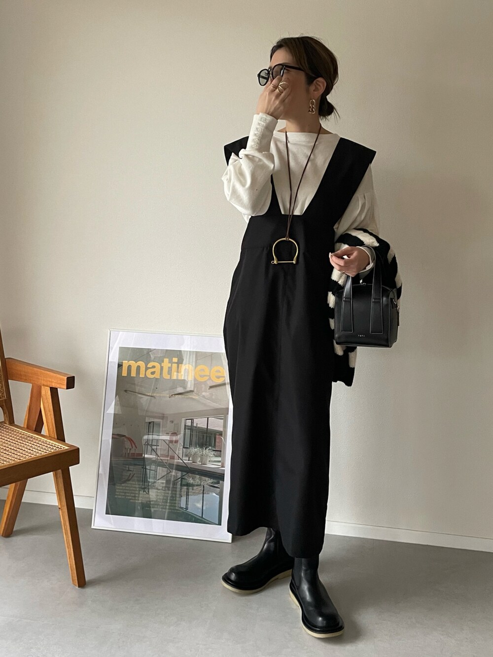 ホワイト系のTシャツ/カットソー、ブラック系のスカート、ブラック系のボストンバッグを着用したレディースの冬コーディネートの5枚目の写真