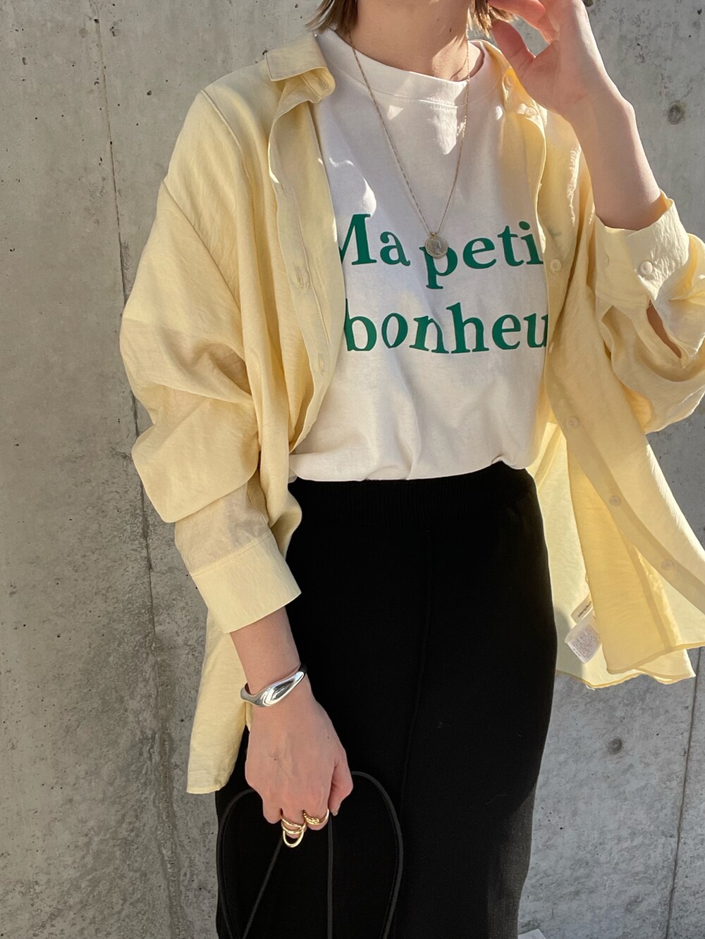 イエロー系のシャツ/ブラウス、ブラック系のサンダル、ブラック系のショルダーバッグを着用したレディースの春コーディネートの3枚目の写真