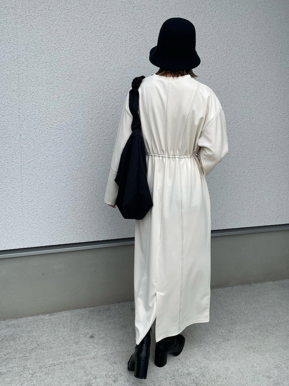 ホワイト系のワンピース、ブラック系のショルダーバッグ、ブラック系のブーツを着用したレディースの秋コーディネートの5枚目の写真