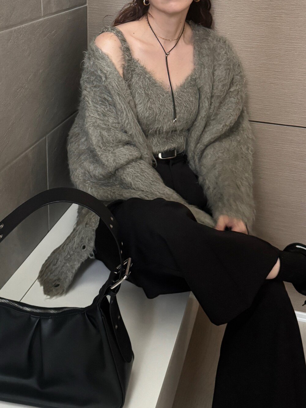 グレー系のカーディガン/ボレロ、ブラック系のスニーカー、ブラック系のハンドバッグを着用したレディースの秋コーディネートの3枚目の写真