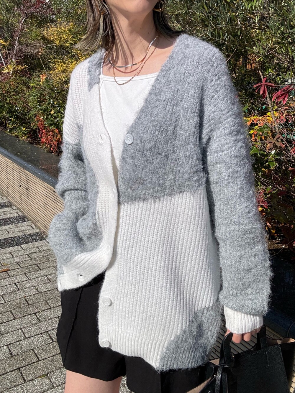 ブラック系のその他パンツ、ブラック系のハンドバッグ、ホワイト系のキャミソールを着用したレディースの秋コーディネートの5枚目の写真