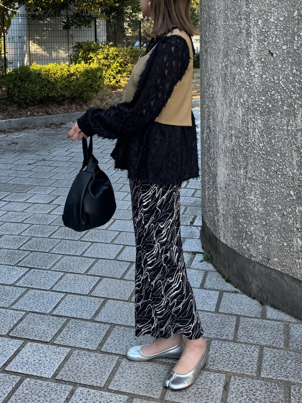 ベージュ系のキャミソール、ブラック系のシャツ/ブラウス、ブラック系のスカートを着用したレディースの春コーディネートの2枚目の写真