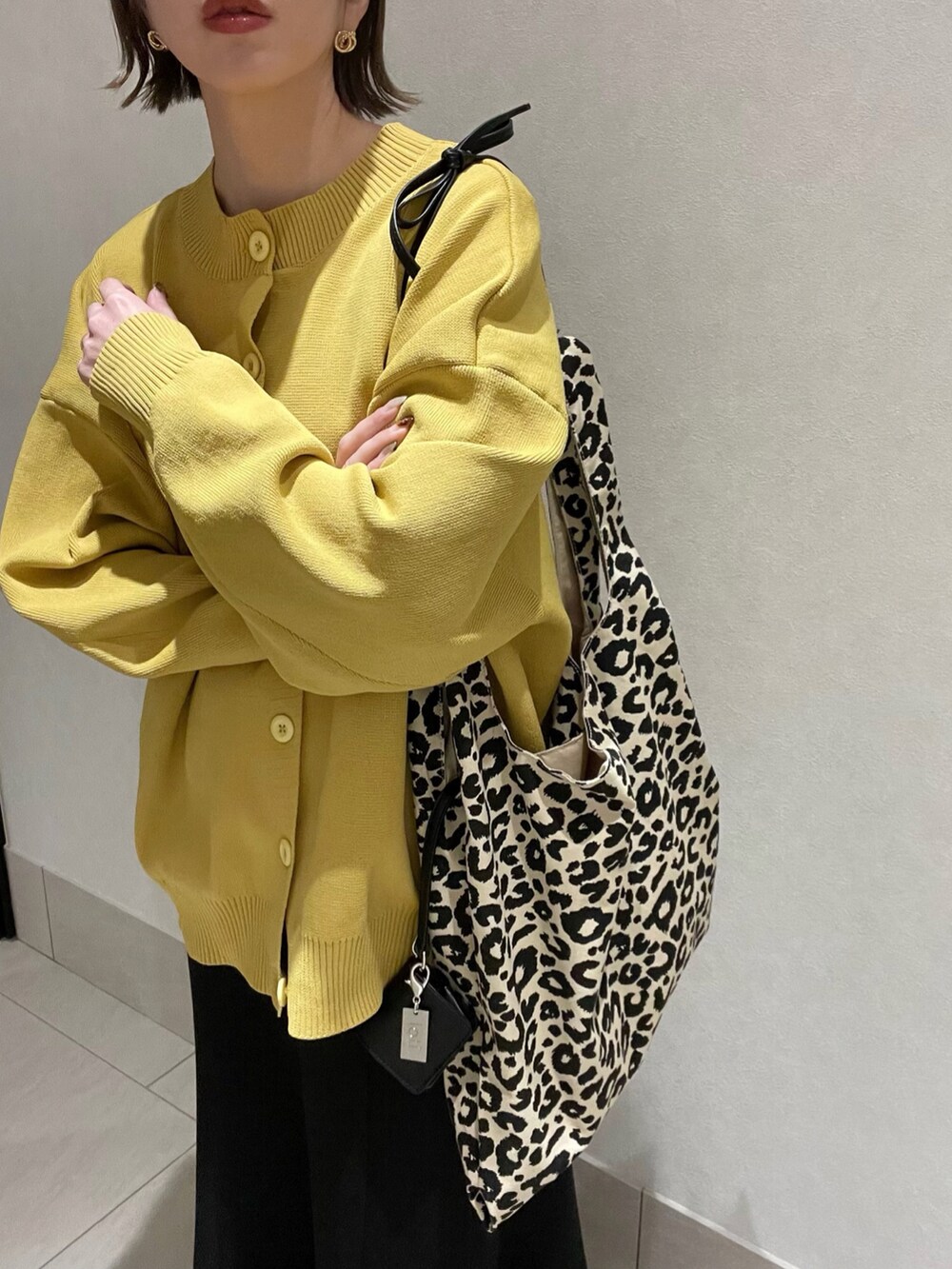 イエロー系のニット/セーター、その他のトートバッグ、ブラック系のスカートを着用したレディースの冬コーディネートの3枚目の写真