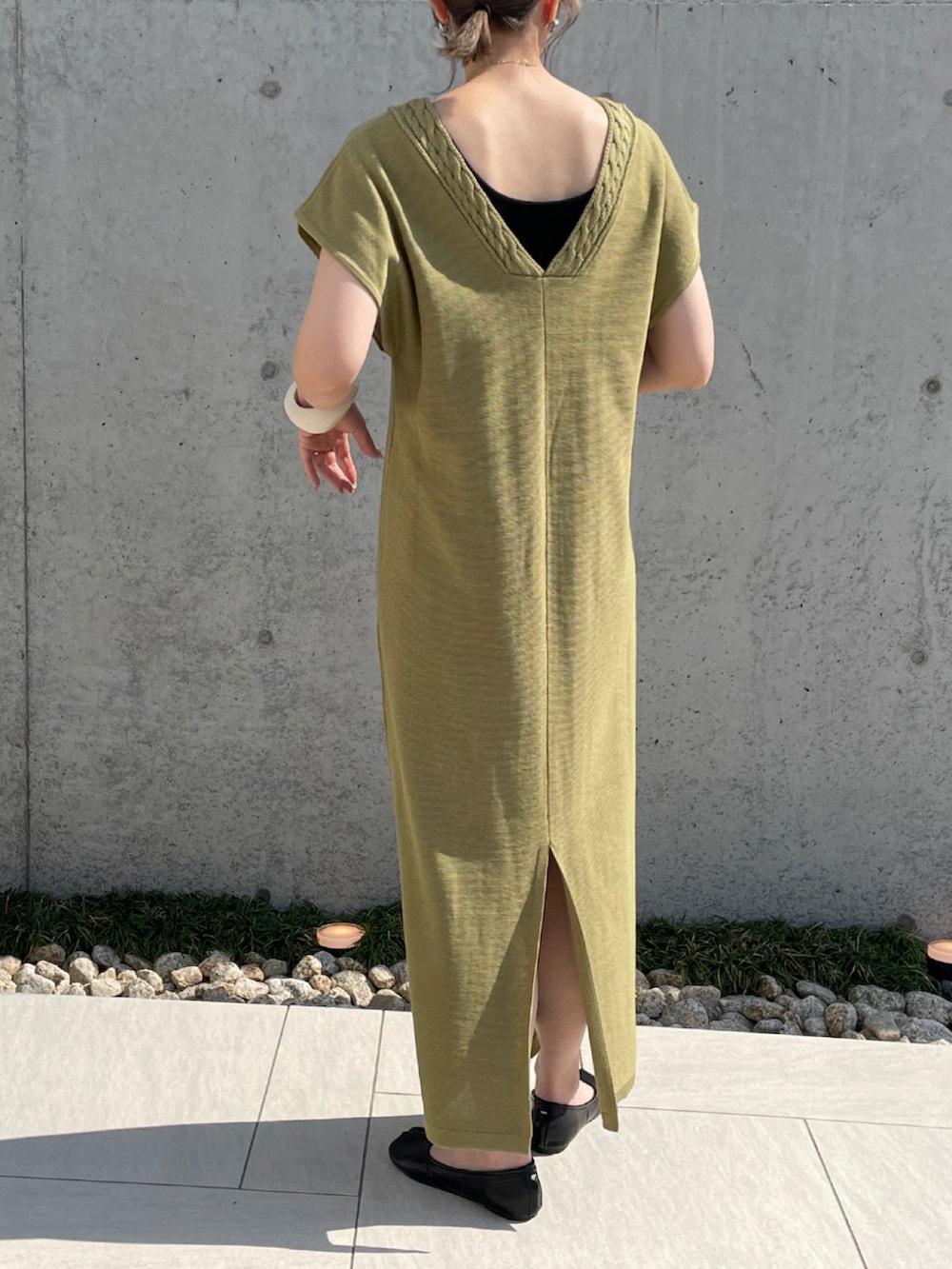 グリーン系のワンピース、ブラック系のパンプス、ホワイト系のブレスレットを着用したレディースの夏コーディネートの5枚目の写真