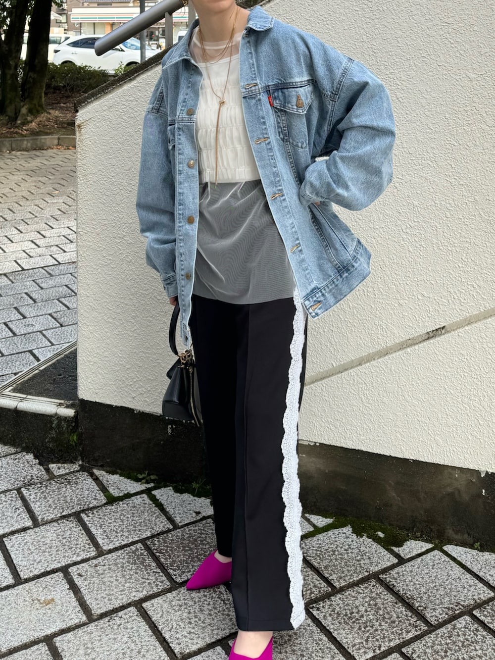 ブルー系のデニムジャケット、ブラック系のその他パンツ、ブラック系のハンドバッグを着用したレディースの冬コーディネートの3枚目の写真