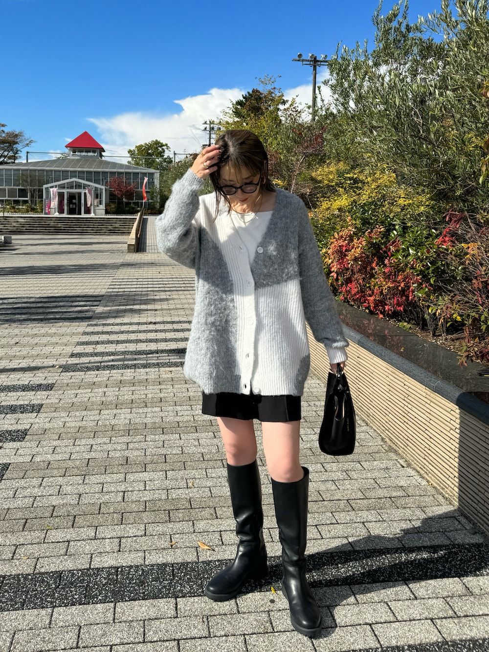 ブラック系のその他パンツ、ブラック系のハンドバッグ、ホワイト系のキャミソールを着用したレディースの秋コーディネートの3枚目の写真