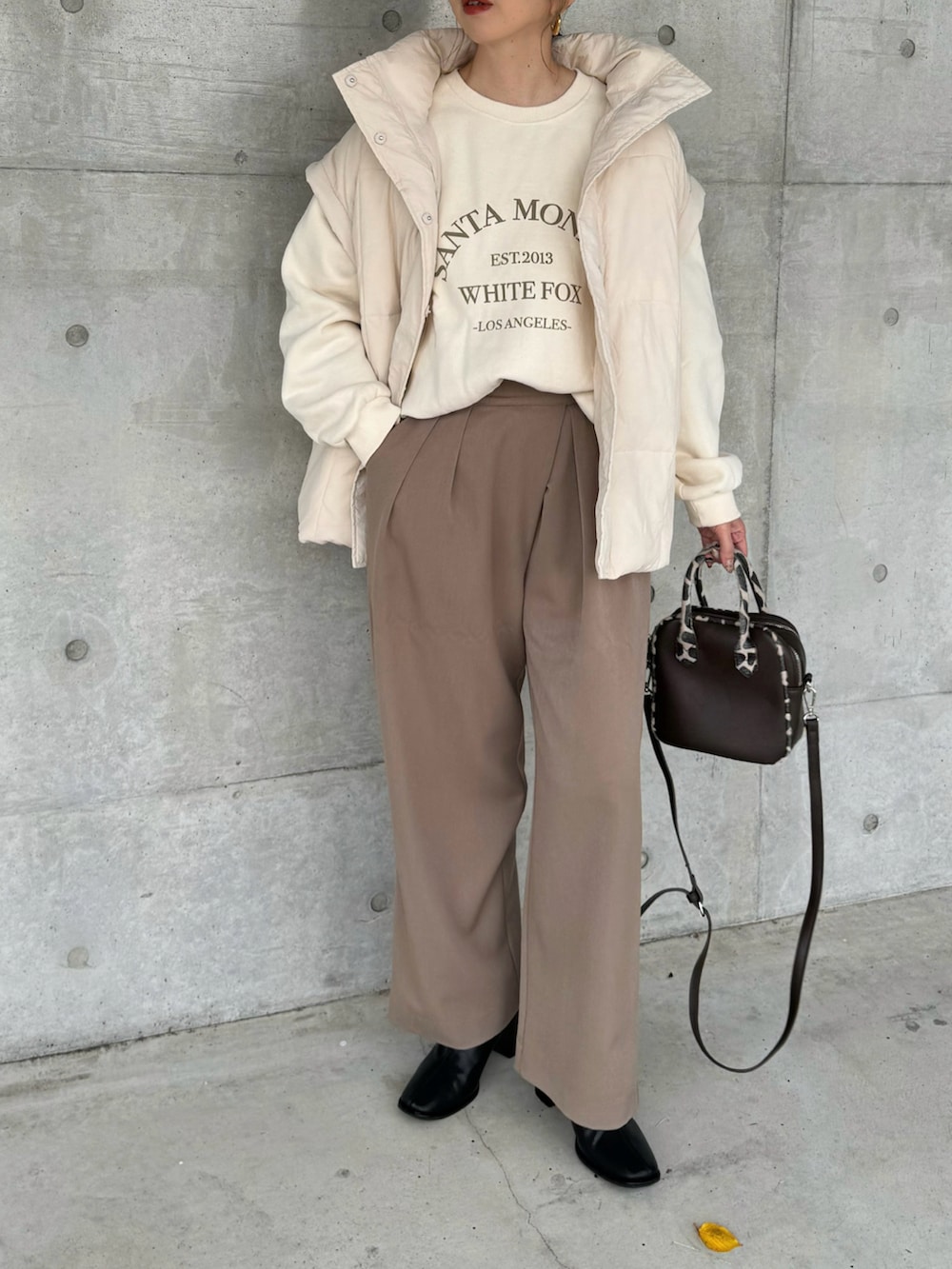 ホワイト系のその他アウター、ブラウン系のその他パンツ、ブラック系のブーツを着用したレディースの秋コーディネートの2枚目の写真