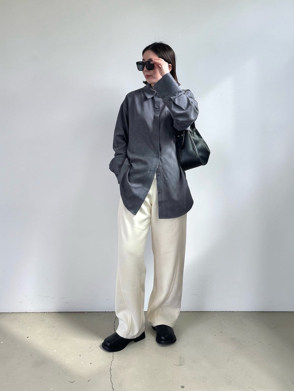 ホワイト系のスウェットパンツ、グレー系のシャツ/ブラウス、ブラック系のハンドバッグを着用したレディースの春コーディネートの3枚目の写真