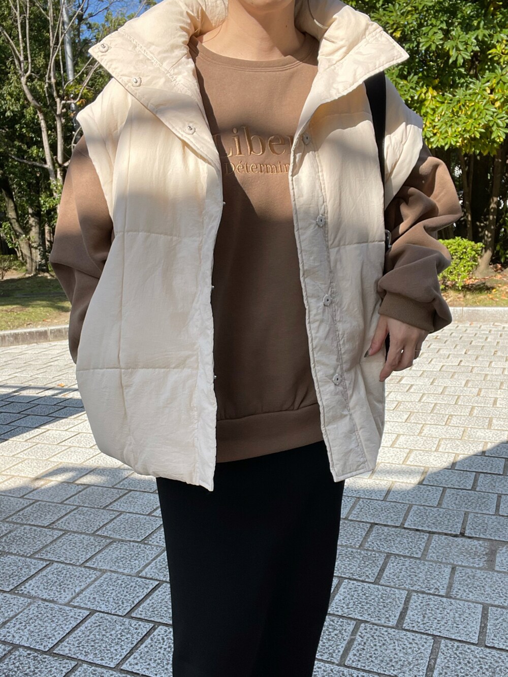 ホワイト系のその他アウター、ブラック系のスカート、ブラック系のブーツを着用したレディースの秋コーディネートの5枚目の写真