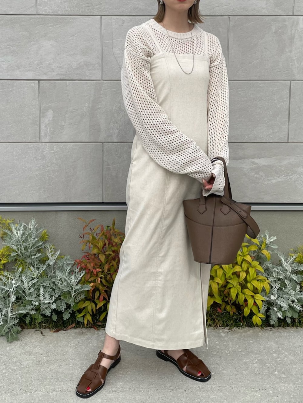 ホワイト系のワンピース、ブラウン系のショルダーバッグ、ブラウン系のサンダルを着用したレディースの春コーディネートの2枚目の写真