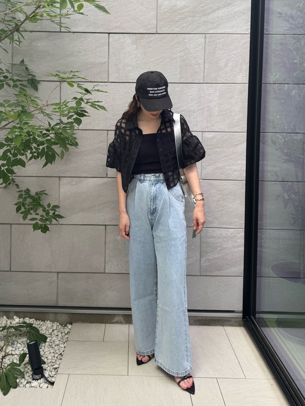 ブラック系のキャミソール、ブラック系のサンダル、ブルー系のデニムパンツを着用したレディースの夏コーディネートの2枚目の写真