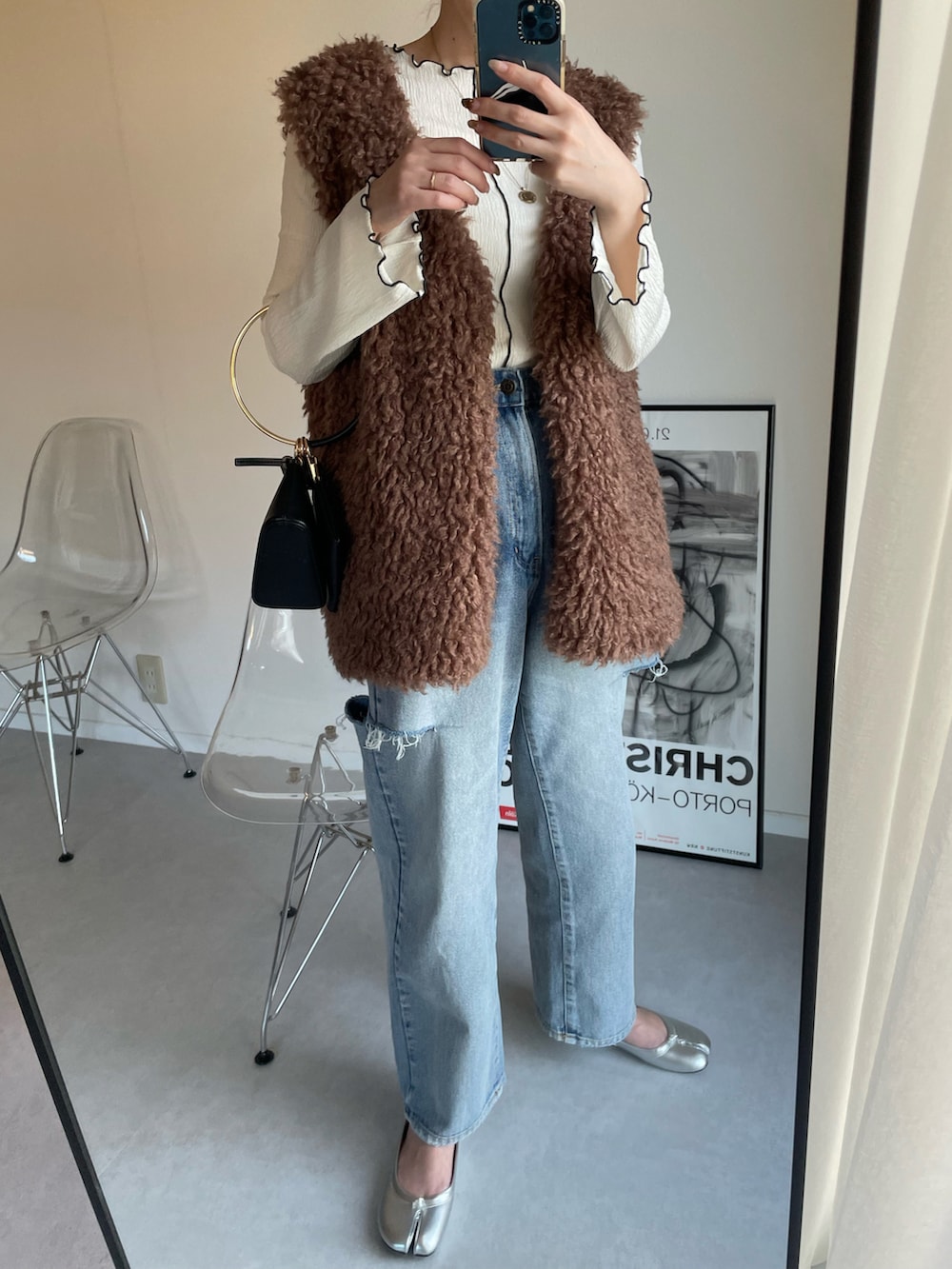 ホワイト系のTシャツ/カットソー、ブラウン系のベスト、ブラック系のハンドバッグを着用したレディースの春コーディネートの2枚目の写真