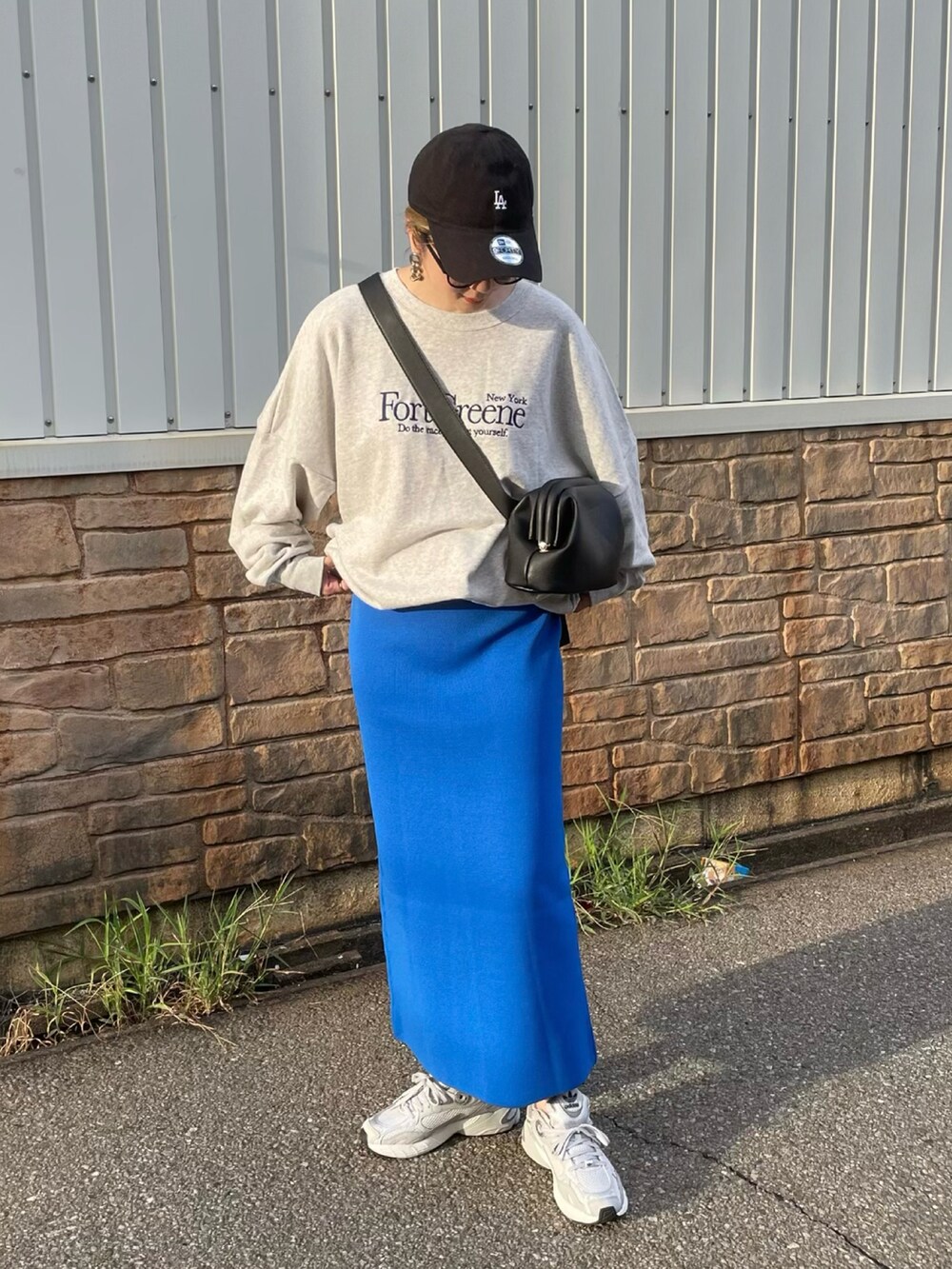 ブルー系のスカート、グレー系のスウェット、グレー系のスニーカーを着用したレディースの秋コーディネートの3枚目の写真