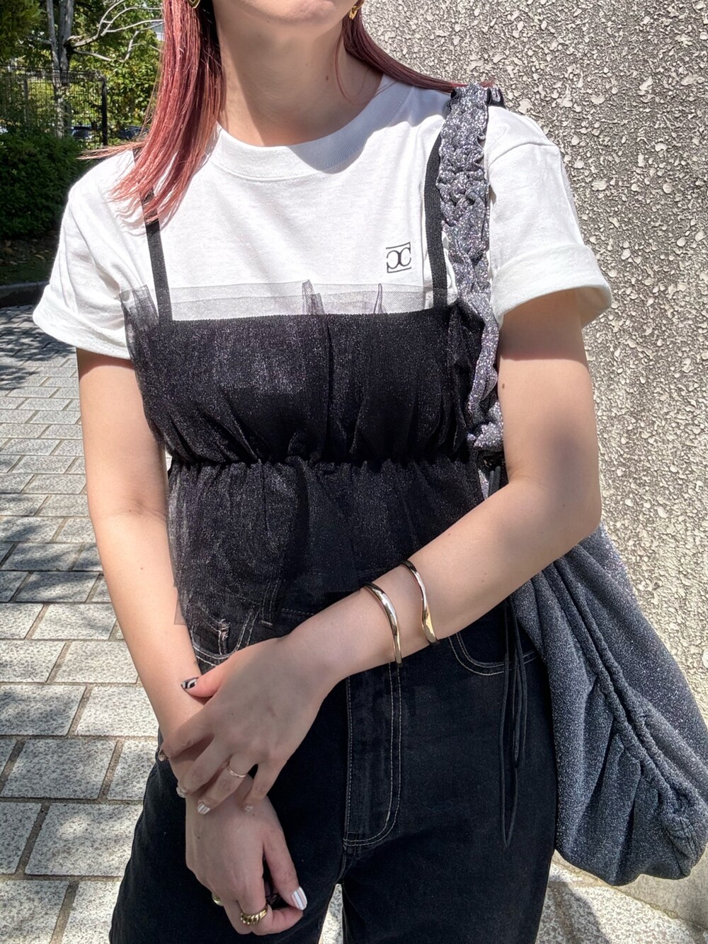 ホワイト系のTシャツ/カットソー、ブラック系のデニムパンツ、シルバー系のトートバッグを着用したレディースの春コーディネートの4枚目の写真