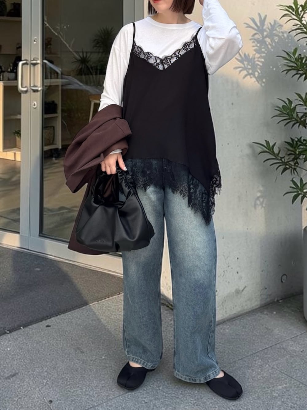 ブラウン系のシャツ/ブラウス、ブルー系のデニムパンツ、ブラック系のショルダーバッグを着用したレディースの春コーディネートの3枚目の写真