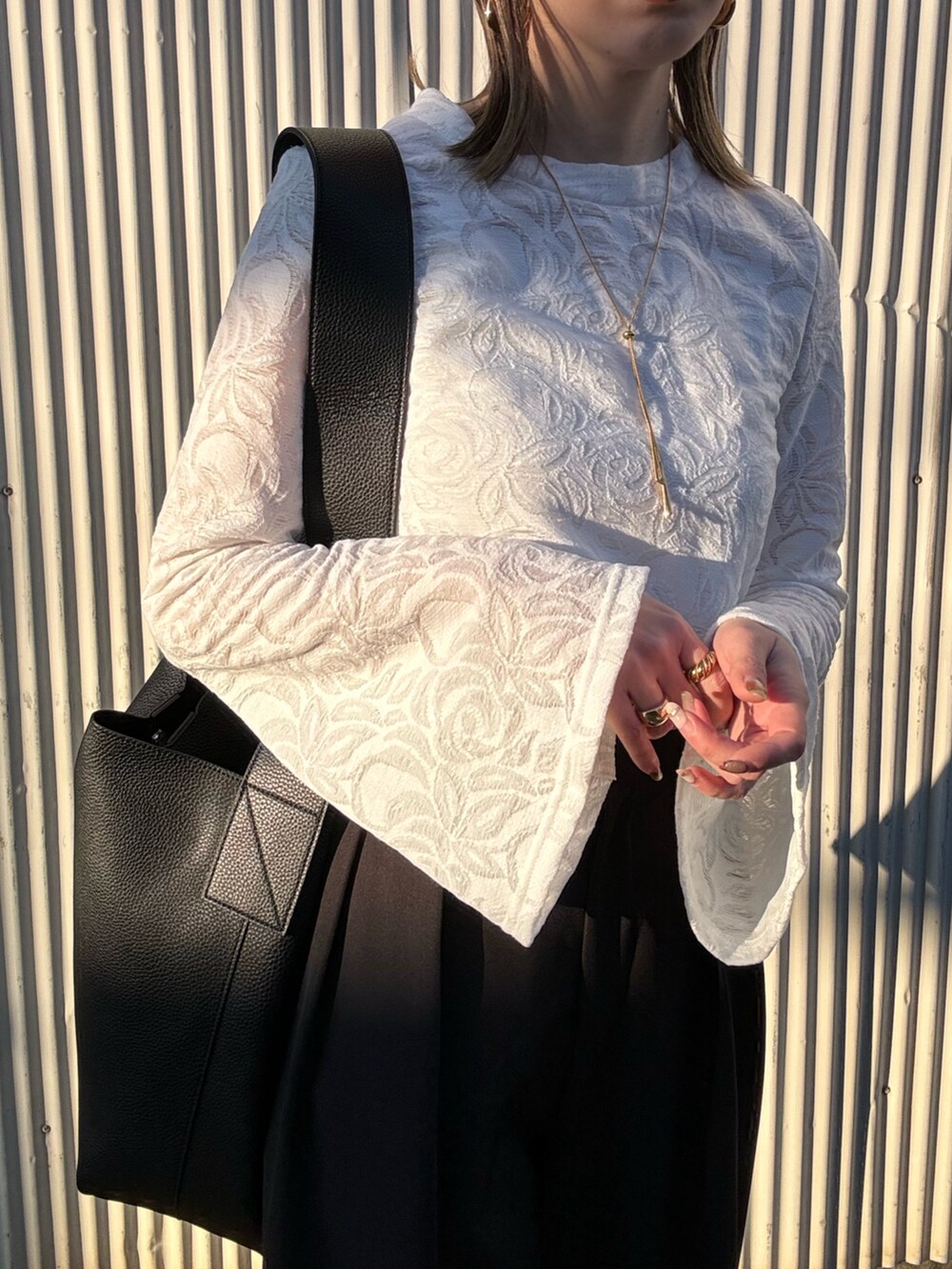 ホワイト系のTシャツ/カットソー、ブラック系のその他パンツ、シルバー系のパンプスを着用したレディースの冬コーディネートの4枚目の写真