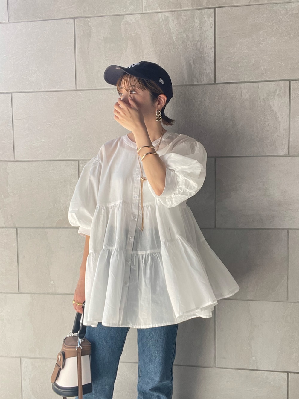 ホワイト系のシャツ/ブラウス、ブルー系のデニムパンツ、ホワイト系のサンダルを着用したレディースの夏コーディネートの3枚目の写真