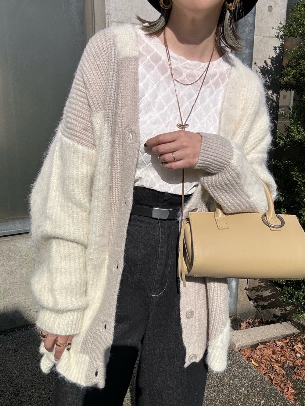 ホワイト系のカーディガン/ボレロ、ホワイト系のTシャツ/カットソー、ベージュ系のハンドバッグを着用したレディースの秋コーディネートの5枚目の写真