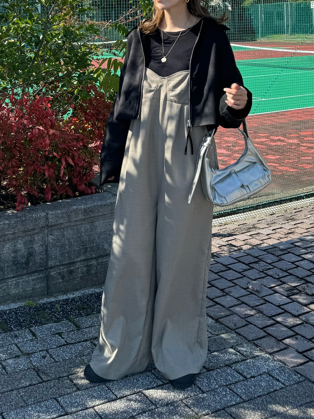 ブラック系のその他アウター、シルバー系のショルダーバッグ、ブラック系のTシャツ/カットソーを着用したレディースの秋コーディネートの3枚目の写真