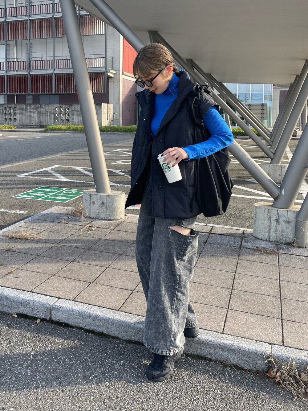 ブルー系のニット/セーター、ブラック系のデニムパンツ、ブラック系のスニーカーを着用したレディースの秋コーディネートの2枚目の写真